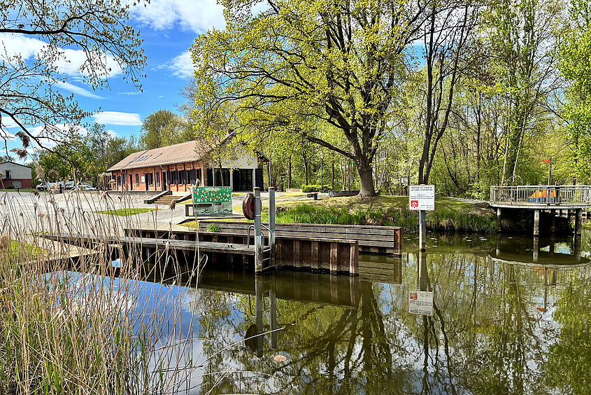 Wasser mit Steg und Haus im Hintergrund
