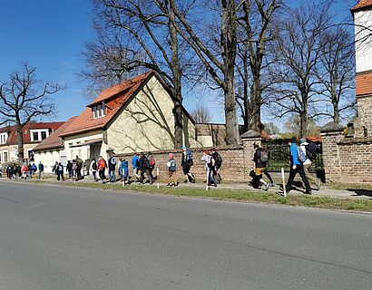 Wander*innen laufen druch den Ort Kickebusch