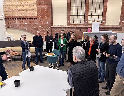 Hier ist eine Gruppe von Menschen zu sehen, die in einem Halbkreis stehen.