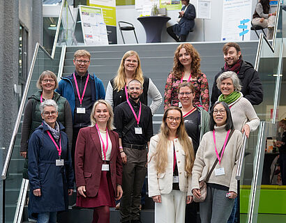 Team der THCONNECT 2025 bei einem Gruppenfoto auf der Treppe im Foyer von Halle 17