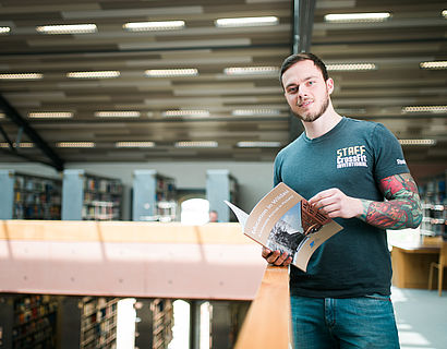 Student lesend in der Bibliothek