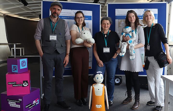 Gruppenfoto von Teilnehmern der MS Wissenschaft Tour Potsdam vor zwei Stellwänden mit Informationspostern