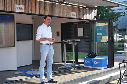 Eine Person steht in der offenen ScienceBox auf dem Campus der TH Wildau und hält einen Vortrag