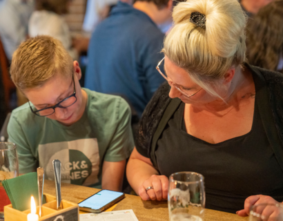 Ein Kind und eine Frau schauen zusammen auf ein Smartphone.