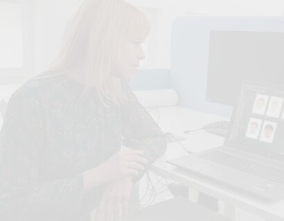 Blonde Frau betrachtet Laptop mit generierten Phantombildern