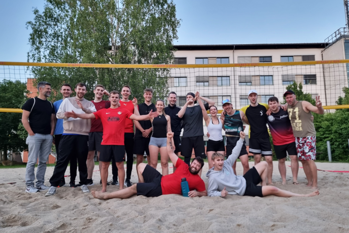 Gruppenfoto auf Beachvolleyballplatz