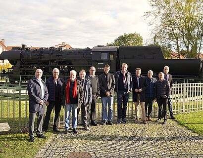 Delegation von Stiftung heureka und Vertreter*innen der TH Wildau vor der Lokomotive auf dem Campus der TH Wildau