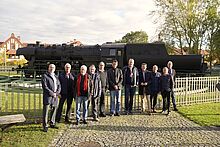 Delegation von Stiftung heureka und Vertreter*innen der TH Wildau vor der Lokomotive auf dem Campus der TH Wildau