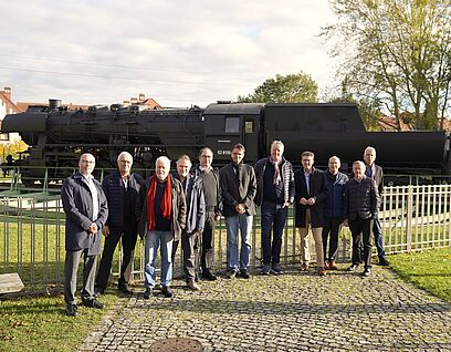 Delegation von Stiftung heureka und Vertreter*innen der TH Wildau vor der Lokomotive auf dem Campus der TH Wildau