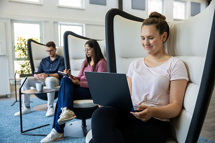 Drei Studierende im Opp:Lab am Laptop im Ohrensessel