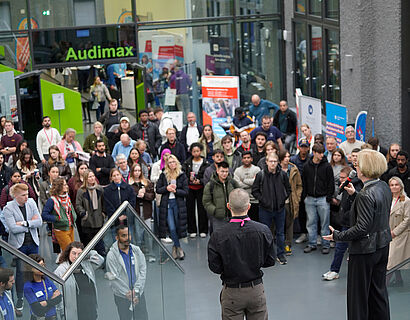 Prof. Ulrike Tippe und Ray Trautwein bei der Eröffnung der THCONNECT 2025 von hinten fotografiert mit den Besucher*innen im Hintergrund