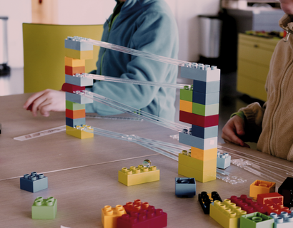 Kinder spielen mit einer Kugelbahn von Lego
