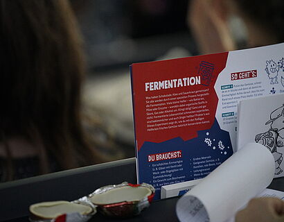 Kinderuni Winter Edition 2024 - Flyer zum Them Fermentation auf dem Tisch im Audimax der TH Wildau
