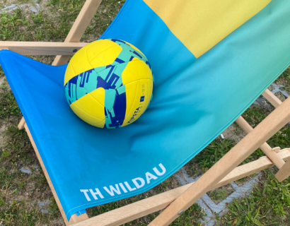 Ein Volleyball liegt auf einem Beachsessel