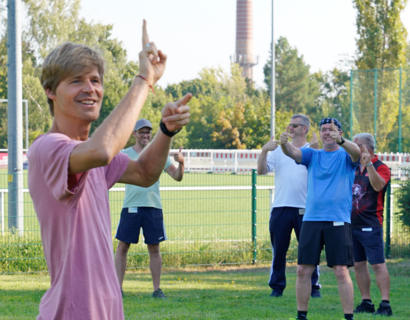 Mann turnt Übungen auf einem Sportplatz vor
