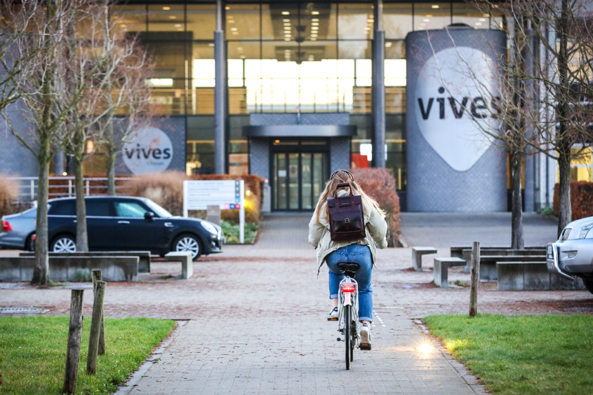 Auf dem Weg zur „Hogeschool“. Studierende der TH Wildau haben ab dem Wintersemester 2024/25 die Möglichkeit, sich für einen belgisch-deutschen Doppelabschluss zu entscheiden. Bild: Copyright VIVES Hogeschool Studierende mit dem Rad auf dem Weg zur VIVE Hogeschool (im Hintergund)