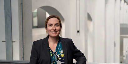 Portraitbild von Prof. Susanne Marx in Halle 14 mit heller Architektur im HIntergrund