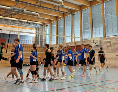 Menschen in Sportkleidung begrüßen sich an einem Volleyball-Netz