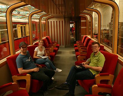 Gruppenbild von Exkusion-Teilnehmenden in einem alten S-Bahn-Zug im S-Bahn-Werk Erkner