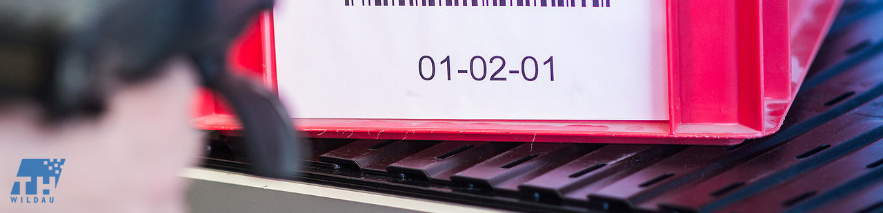 Behälter mit Barcode wird mittels MDE-Gerät gescannt