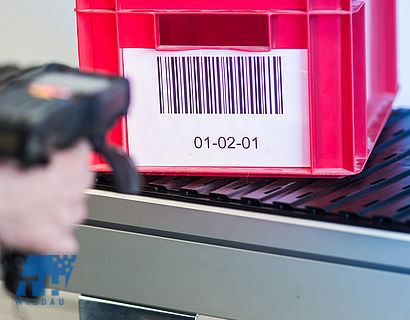 Behälter mit Barcode wird mittels MDE-Gerät gescannt