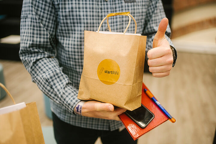 Übergabe Goody Bag an Teilnehmer der Eröffnungsveranstaltung