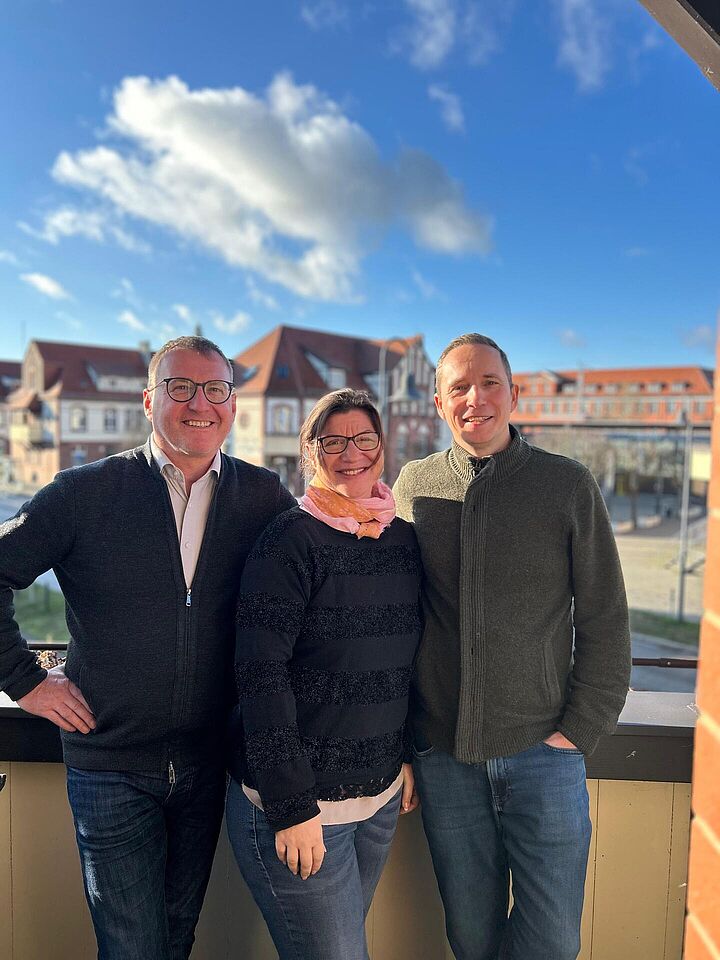 Prof. Wolf, Prof. Lübbe und Susanne Trotzki vor ihre Aufnahme zu den TH THemen auf einem Balkon. Im Hintergund Wildau.