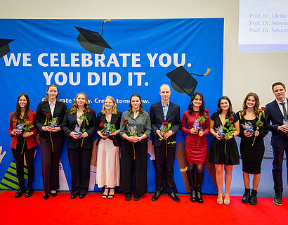 Absolvent*innen posieren für ein Gruppenfoto bei der Verabschiedung 2025