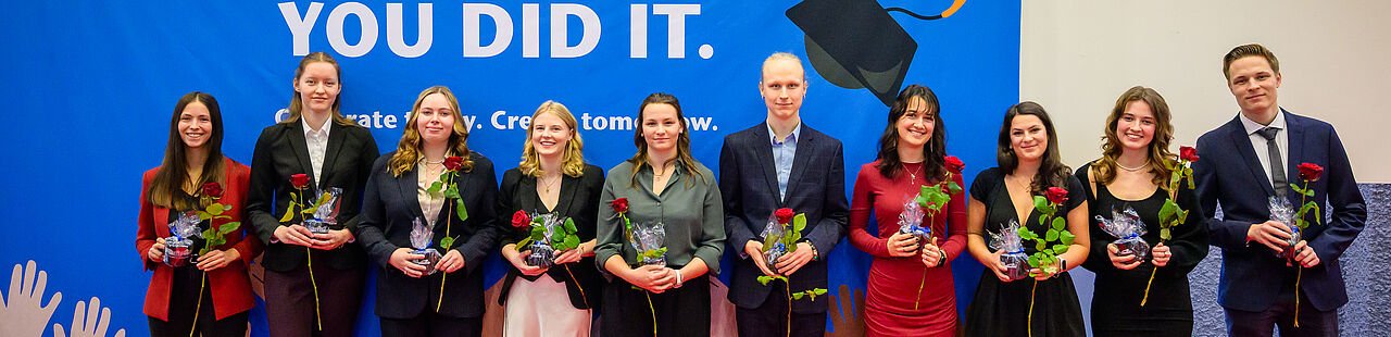 Absolvent*innen posieren für ein Gruppenfoto bei der Verabschiedung 2025