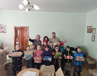 Kinder mit Päckchen in der Hand bei Übergabe in Charkiw im Rahmen der Weihnachtsaktion