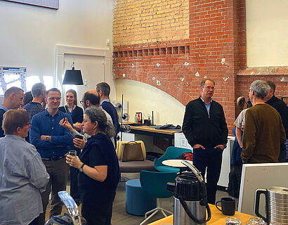 In diesem Foto sind drei kleine Gruppen von Menschen zu sehen, die sich miteinander unterhalten.