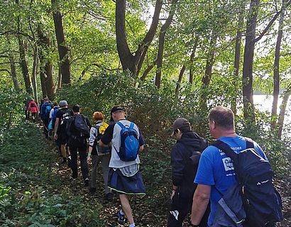 Wander/-innen im Laubwald