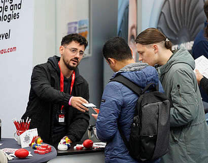Ausstellende und Besucher*innen bei einem Gespräch an einem Stand bei der THCONNECT 2025
