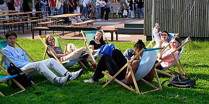 Studierende auf Liegestühlen auf einer Campuswiese der TH Wildau