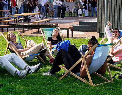 Studierende auf Liegestühlen auf einer Campuswiese der TH Wildau