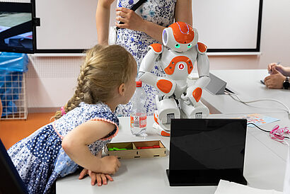 Kleiner androider Roboter und Mädchen