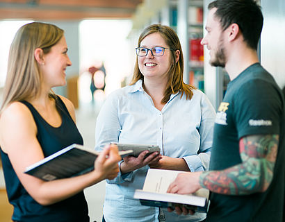 Foto von Studenten die sich im Flur unterhalten