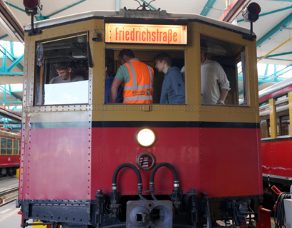 Menschen stehen im Führerhaus einer historischen S-Bahn