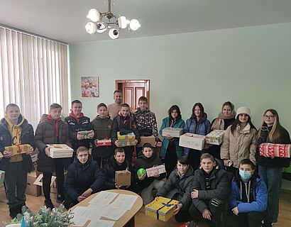 Kinder mit Päckchen in der Hand bei Übergabe in Charkiw im Rahmen der Weihnachtsaktion