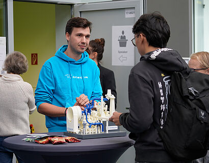 Austellende und Teilenehmende im Gespräch an einem Stand bei der THCONNECT 2025