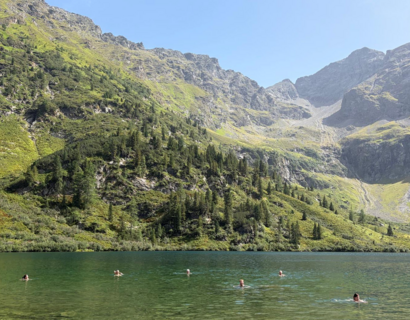 Menschen baden in einem Bergsee