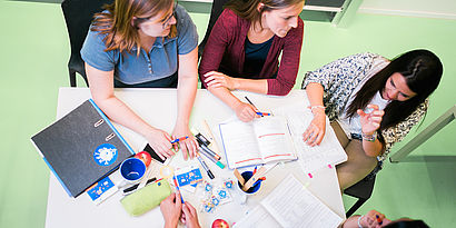 Studierende beim Gespräch am Tisch