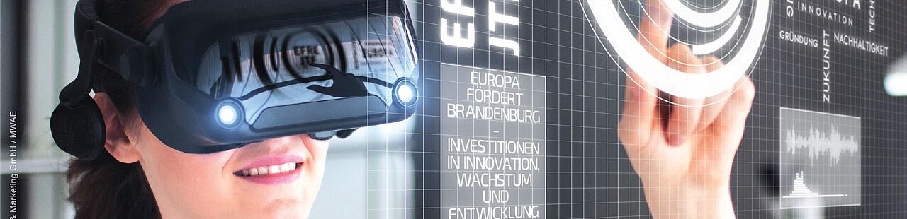 Eine Frau mit VR Brille tippt auf ein Zeichen auf einem virtuellen Board