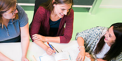 Studierende sitzen am Tisch 