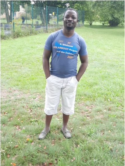 Ein Mann mit einem T-Shirt zur „Wildauer Solarboot-Regatta 2021“ steht auf einer Wiese.