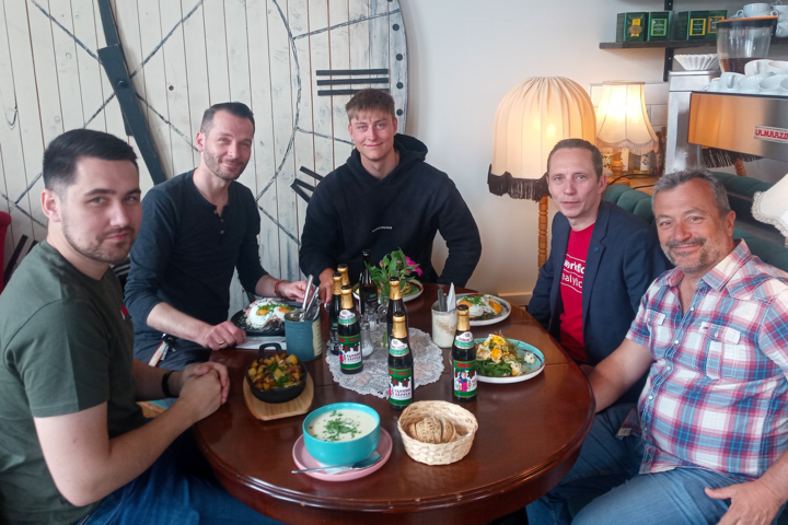 Personen sitzen um einen gedeckten Tisch