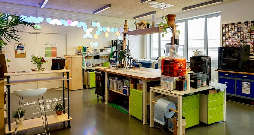 Photo of a makerspace with a workbench and equipment in the background.