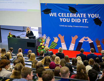 Prof. Verena Klapschus spricht vor einem voll besetzten Audimx