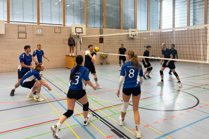 Menschen spielen Volleyball in einer Turnhalle