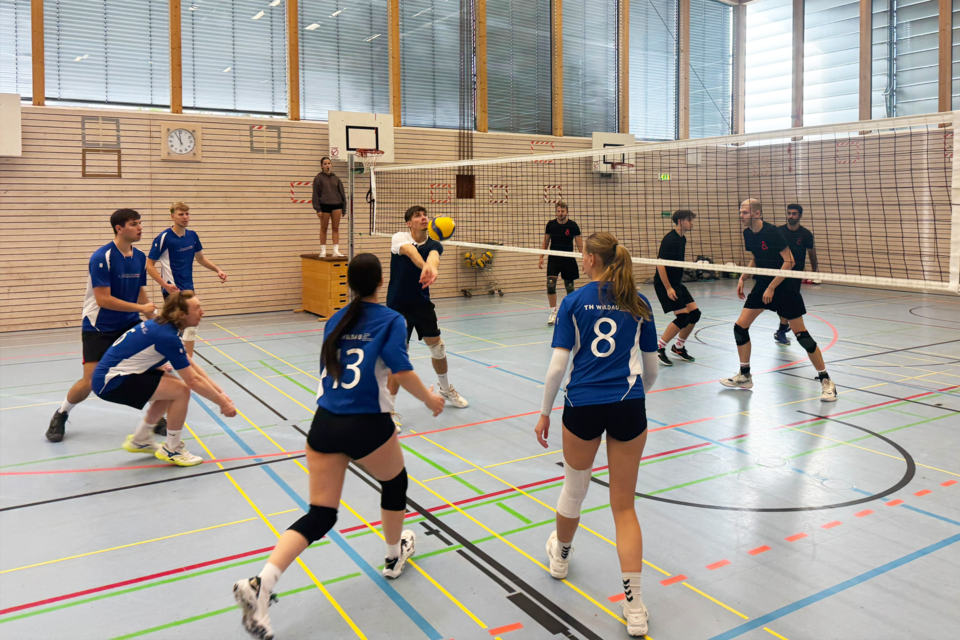 Menschen spielen Volleyball in einer Turnhalle